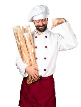 Young baker holding some bread and pointing down Stock Photos