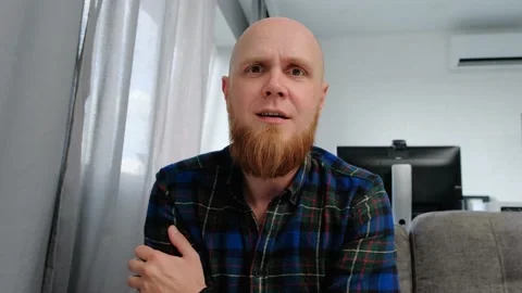 A young bald guy communicates with interest via video chat. Stock Footage 139192555