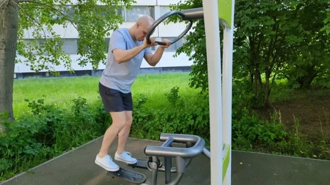 Young bald man doing gymnastics in city park. Calf muscle training Video stock 200401049