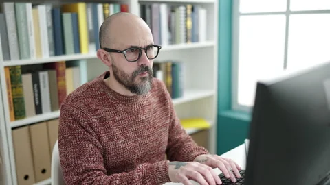 Young bald man student using computer stressed at university classroom 스톡 동영상 236535418