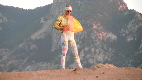 Young bald slender freak man in tight leggings, golden jacket, bandage Stock Footage 138933648