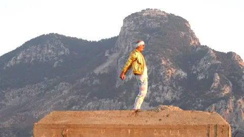 Young bald slender freak man caucasian in tight leggings, gold jacket Stock Footage 138938501