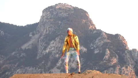 Young bald slender freak man caucasian in tight leggings, gold jacket Stock Footage 138939154
