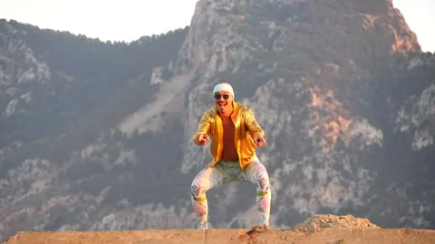 Young bald slender freak man in tight leggings, gold jacket, bandage Stock Footage 138940697