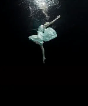 A young ballerina is dancing underwater Stock Photos