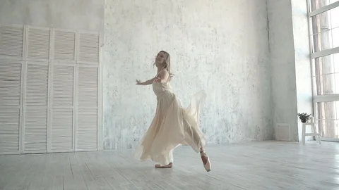A young ballerina is dancing in a white light dress. ballet dancer in pointe Stock Footage 88363593