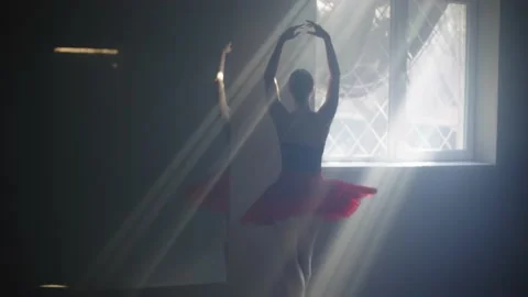 A young ballerina performs a dance in the rays of the sun from the window. Stock Footage 237914941
