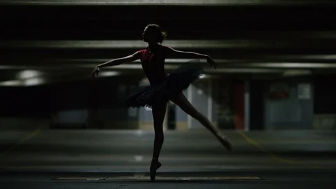 Young ballet dancer balances on pointe in a car park, in slow motion Stock Footage 85613588