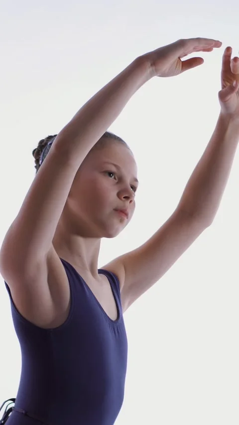 Young ballet dancer in a purple ballet leotard, performing exercises during a Stock Footage 314434074
