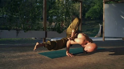 Young Barefoot Guy with Naked Torso Performs Yoga Asan on Wood Aide Early in the Stock Footage 85376149
