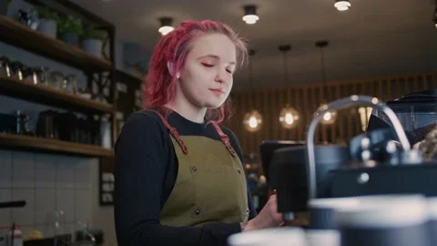 A young Barista Girl Makes delicious coffee. Coffee shop worker with a modern Stock Footage