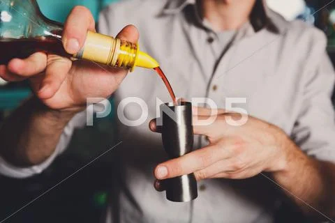 Young Barman's making shot cocktail, pouring syrup into glass Stock Photos