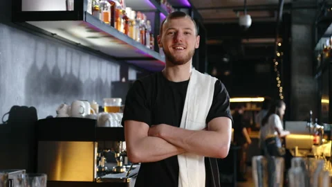 Young bartender looking at the camera and smiling. slow motion Stock Footage 236958995