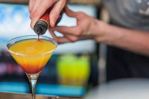 Young bartender or a waiter making a cocktail Stock Photos