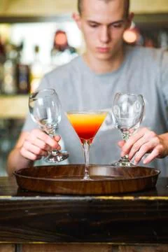 Young bartender or a waiter making a cocktail Stock Photos