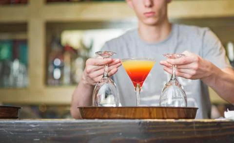 Young bartender or a waiter making a cocktail Stock Photos