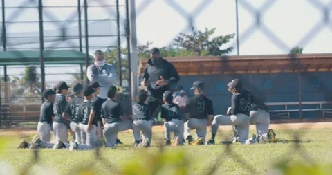 Young baseball team on the field getting pep talk from coaches Stockbeeldmateriaal 231948143