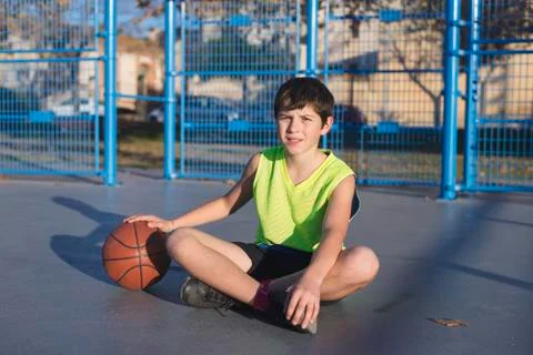 Young basketball player sitting on the court Stock Photos