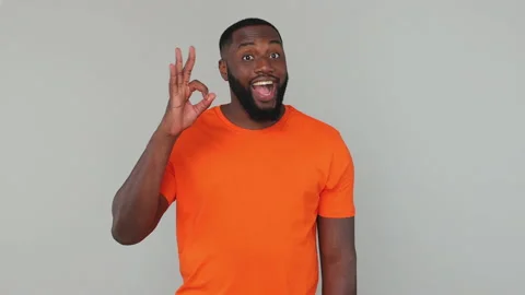 Young bearded african american guy 20s in orange basic casual t-shirt look at Stock Footage 148317128