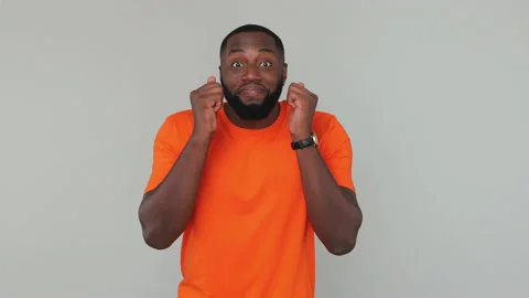 Young bearded african american guy 20s in orange basic t-shirt look at camera Stock Footage 148317166