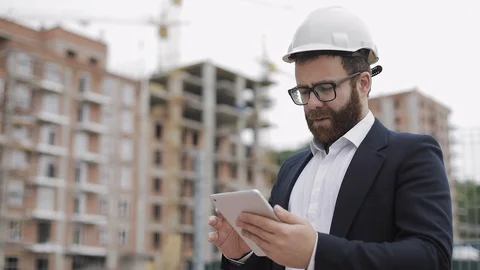 Young bearded architect at the construction site taking photo with tablet. He Stock Footage 109485113
