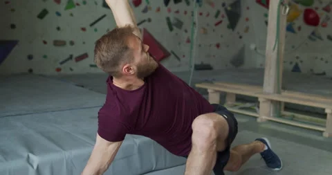 Young bearded athlete warming up before training on climbing wall Stock Footage 131331941