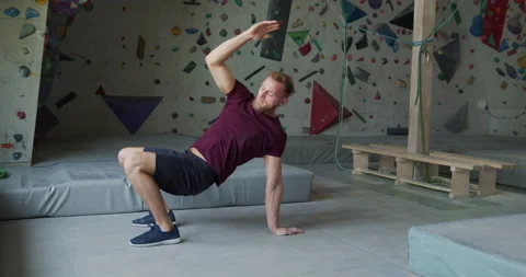 Young bearded athlete warming up before training on a climbing wall Stock Footage 131333119