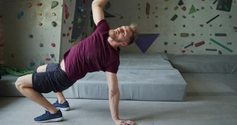 Young bearded athlete warming up before training on a climbing wall Stock Footage 131333701