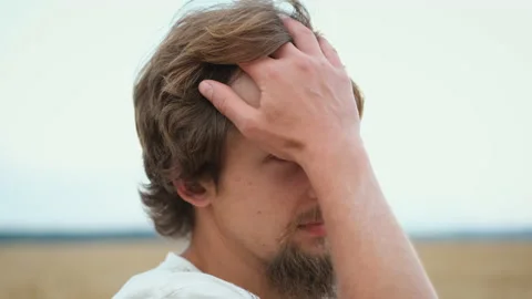 A young bearded brunette farmer stands in a field and admires the harvest and Vídeo Stock 133833089