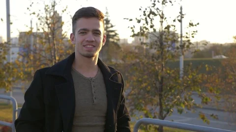 Young bearded business man in coat walk on street, smile on street with sunlight Video stock 80987135