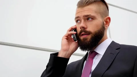 Young bearded businessman using mobile phone outside the office Stock Footage 60945251