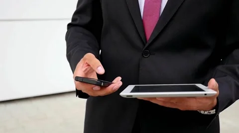 Young bearded businessman using tablet pc and mobile phone. Close up. Stock Footage 60944917