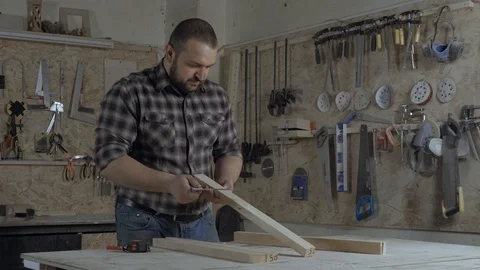 Young bearded carpenter standing at his workplace in carpentry shop Stock Footage 101329854