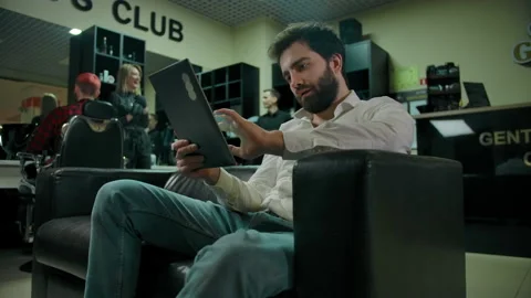 Young bearded caucasian man checking socials on a tablet PC Stock Footage 133512355