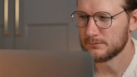 Young bearded caucasian man in computer glasses works on laptop at home. Student Stockbeeldmateriaal 198478833