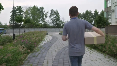 Young bearded courier delivering parcels to client house Stock Footage 122688043