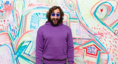 Young bearded crazy man looking happy and pleasantly surprised, excited with  Stock Photos