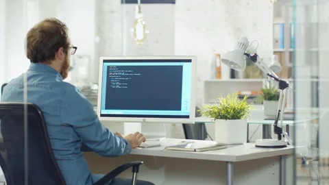 Young Bearded Developer Writes Code on His Desktop Computer. Stock Footage 70659316