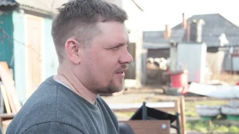 A young bearded farmer drinking beer from a plastic bottle Stock Footage 74947695