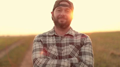 A young bearded farmer puts on a cap. Stock Footage 265551712