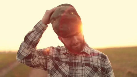 A young bearded farmer puts on a cap. Stock Footage 265551851