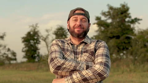 A young bearded farmer puts on a cap. Stock Footage 265552273