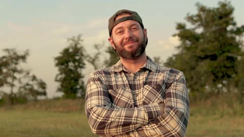 A young bearded farmer puts on a cap. Stock Footage 265552515