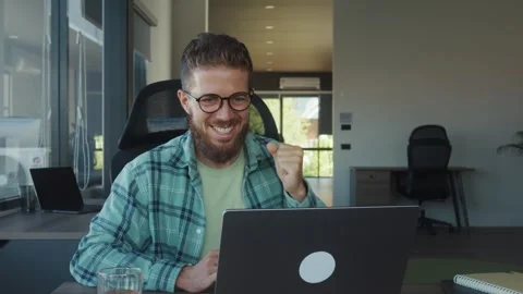 Young, bearded freelancer is expressing excitement and celebrating professional Stock Footage 312123346