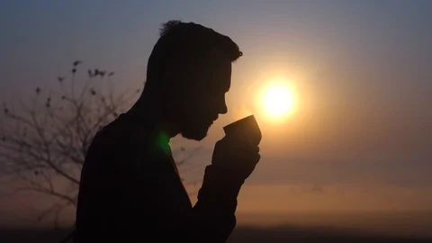 Young bearded guy drinking coffee at dawn.Coffee in the morning at sunrise Stock Footage 119712820