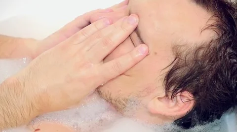 Young bearded guy having a foam bath relaxing Stock Footage 54355577