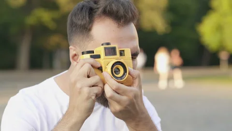 Young bearded guy looking aside, smiling nad taking pictures on the camera. Stock Footage 115633460