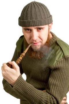 Young bearded guy smoking a pipe Stock Photos