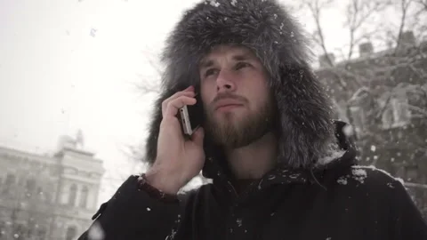 A young bearded guy talking on the phone in winter. Stock Footage 85592295