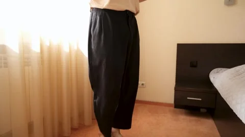 A young bearded guy wearing wireless headphones listens to music and dances to Stock Footage 278364126